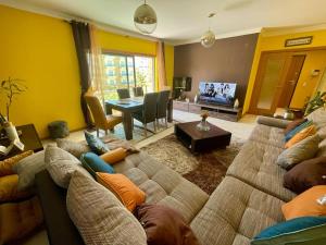 a living room with a couch and a dining room at Belle suite / belles vacances in Olhão