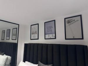 ラゴスにあるCOC00N by IVYの壁に3枚の写真が飾られたベッドルーム、ベッド1台が備わるベッドルーム1室