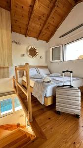 ein Schlafzimmer mit einem Bett mit einem Koffer darin in der Unterkunft Del Sol Suites in Skiathos-Stadt