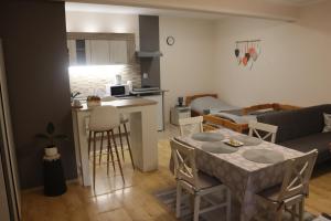 a kitchen and living room with a table and a couch at Chic Apartment Subotica in Subotica
