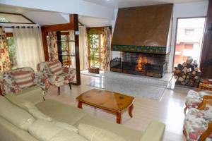 uma sala de estar com um sofá e uma lareira em Apartamento Pousada do Serrano em Gramado