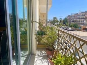 a balcony with potted plants and a view of a street at Belle suite / belles vacances in Olhão