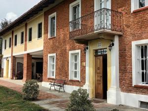 a brick building with a balcony and a wooden door at Guest House La Carolina in Tigliole