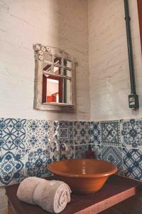 La salle de bains est pourvue d'un lavabo en bois et d'un miroir. dans l'établissement Chalé Gaia com Banheira relaxante, à São Bento do Sapucaí