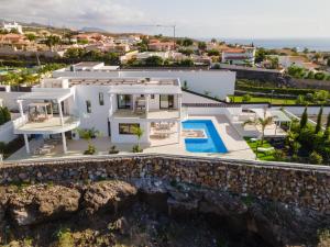 Villa Andrea, quiet luxury, sunset with sea views في أديخي: اطلالة جوية على فيلا بيضاء مع مسبح