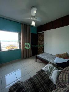 sypialnia z łóżkiem, oknem i kanapą w obiekcie apartamento na praia , pé na areia vista para o mar w mieście Mongaguá