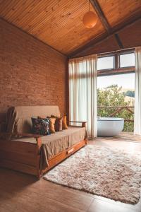 um quarto com uma cama grande e uma banheira em Chalé Gaia com Banheira relaxante em São Bento do Sapucaí