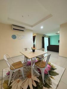 a dining room with a table and chairs and a room at Laguna Raudhah Apartment in Lumut