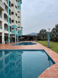 a large swimming pool in front of a building at Laguna Raudhah Apartment in Lumut