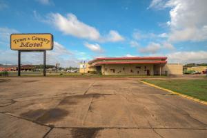 un cartel frente a un edificio con un motel en Town & Country Motel Bossier City by OYO, en Bossier City