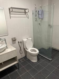 a bathroom with a shower and a toilet and a sink at Laguna Raudhah Apartment in Lumut