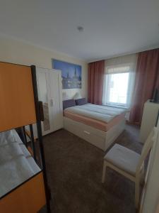 - une chambre avec un lit, une chaise et une fenêtre dans l'établissement Ferienwohnung Lützowhaus, à Lübeck