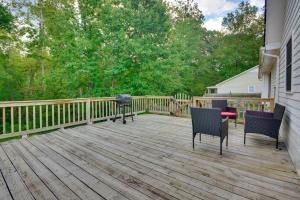 a wooden deck with a grill and chairs on it at Pet Friendly Charming Cozy Greensboro Gem! in Greensboro
