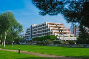 a large building with a park in front of it at Savoy Beach Hotel & Thermal Spa in Bibione