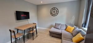 a living room with a couch and a table at Central Reading Modern flat - Walk to station and high street in Reading