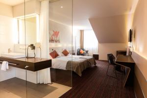 a bedroom with a bed and a sink and a mirror at Riverside in Zweidlen