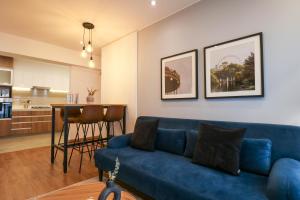 a living room with a blue couch and a kitchen at Great 2BR with Balcony in the Heart of Miraflores in Lima