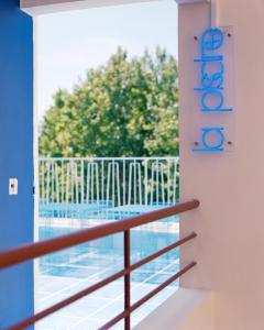 balcón con vistas a la piscina en Hôtel Présent en Arles