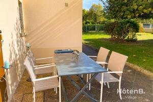a blue table and chairs on a patio at Green Haven T2 with Large Garden in Panazol