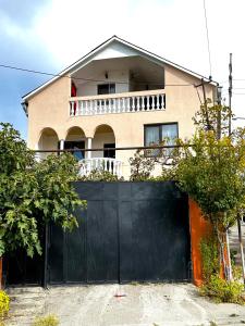 ein Haus mit einem schwarzen Tor vor einem Haus in der Unterkunft Family Guesthouse - MACHARASHVILI in Tbilisi City