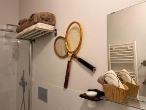 a tennis racket hanging on a wall next to a mirror at Garibaldina75 in Cesena