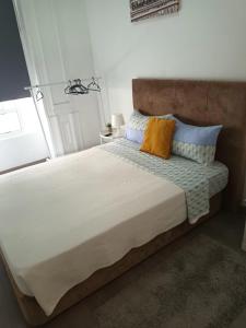 - une chambre dotée d'un grand lit avec des oreillers bleus et oranges dans l'établissement Guesthouse Franco, à Porto