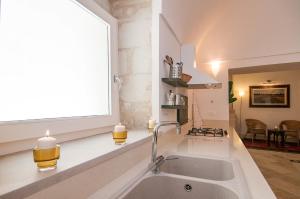 eine Küche mit einem Waschbecken und einem Fenster in der Unterkunft Palazzo Degli Olivi in Modica