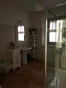 y baño con ducha, lavabo y aseo. en La Maison Apartment, en Fanano