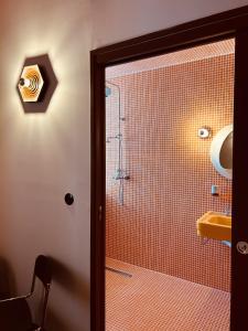 baño con ducha y puerta de cristal en Hôtel Présent en Arles