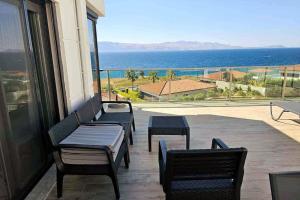 a balcony with chairs and a view of the ocean at Romantic Sea and Chios View Flat in Cesme