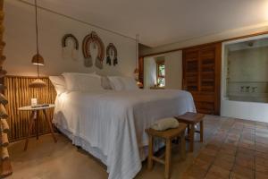 sypialnia z dużym białym łóżkiem w pokoju w obiekcie Vila Morena Altos de Itapororoca w mieście Trancoso