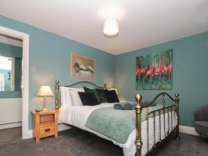 a bedroom with a bed and a painting of flamingos at Stillwater Cottage in Beverley