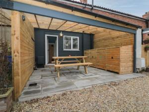 un cobertizo de madera con una mesa de picnic en Stillwater Cottage en Beverley