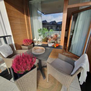 een patio met een tafel en stoelen en een raam bij Bel Mare Resort ekskluzywny apartament dla wymagających klientów in Międzyzdroje