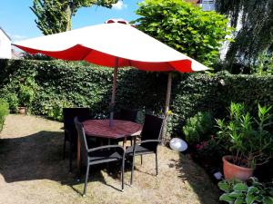 a table and chairs under an umbrella in a garden at Wohnen in einer Privatstrasse in Marl