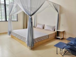 1 dormitorio con 1 cama con dosel en 闲肆民宿 en Sanya