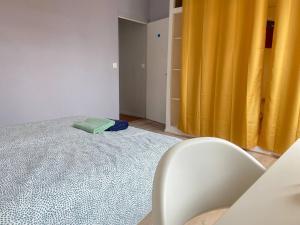 - une chambre avec un lit et un rideau jaune dans l'établissement Maison cosy 5 chambres exterieur centre ville, à Croix