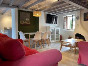 a living room with a red couch and a table and chairs at La Casina de Inesita in Cadavedo