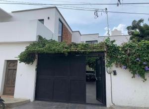 a black garage door with plants on top of it at Hermoso Loft en Santa Anita in Santa Anita