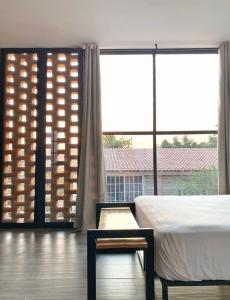 ein Schlafzimmer mit einem Bett und einem großen Fenster in der Unterkunft Hermoso Loft en Santa Anita in Santa Anita