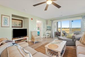 a living room with a couch and a tv at Bethany Bay -- 37185 Harbor #3602 in Ocean View