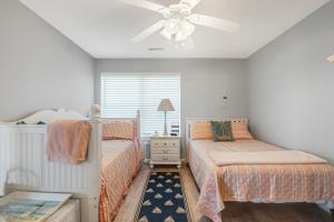 une chambre avec deux lits et un ventilateur de plafond dans l'établissement Bethany Bay -- 37185 Harbor #3602, à Ocean View 30 autres photos
