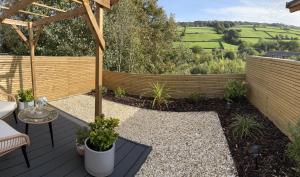 um jardim com um deque de madeira com uma pérgola em Holmfirth Hideaway em Holmfirth