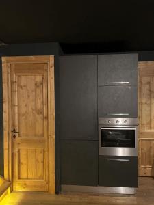 a kitchen with a stove and a refrigerator and a door at chalet Sestriere in Champlas du Col