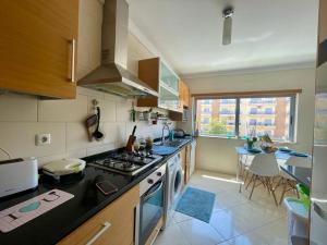 a kitchen with a stove top oven next to a table at Belle suite / belles vacances in Olhão