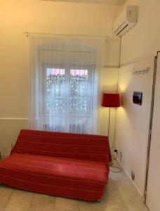 a bedroom with a red bed and a window at THE AIRPORT HOUSE in Catania