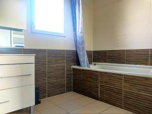 baño con bañera y ventana en Le Clos Andrée - Charmante maison - Zone Nord Montauban - 8 couchages - 3 chambres - Jardin - Parking 3 véhicules - Garage - Climatisation en Montauban
