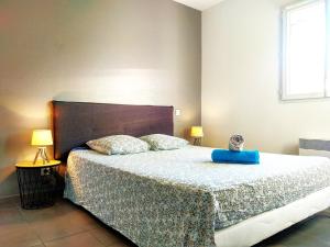 een slaapkamer met een groot bed met een blauw lint erop bij Le Clos Andrée - Charmante maison - Zone Nord Montauban - 8 couchages - 3 chambres - Jardin - Parking 3 véhicules - Garage - Climatisation in Montauban