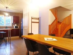 comedor y cocina con mesa de madera y sillas en Le Clos Andrée - Charmante maison - Zone Nord Montauban - 8 couchages - 3 chambres - Jardin - Parking 3 véhicules - Garage - Climatisation en Montauban