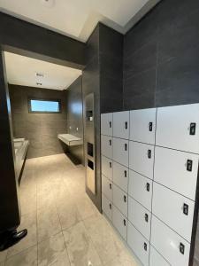 a bathroom with white cabinets and a bath tub at Mid Valley Luxury 6pax Resort谷中城奢华风格套房 in Kuala Lumpur